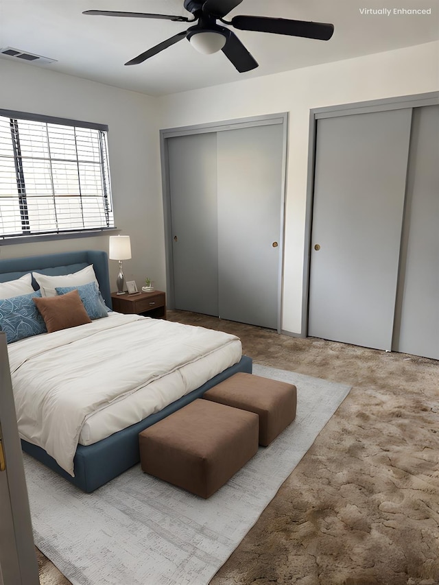 bedroom featuring ceiling fan, carpet flooring, and two closets