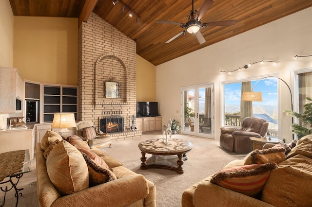 carpeted living room with rail lighting, wood ceiling, ceiling fan, high vaulted ceiling, and a fireplace