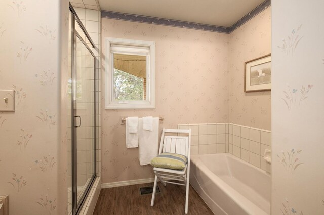 bathroom with hardwood / wood-style flooring and independent shower and bath