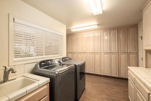 clothes washing area featuring cabinets, independent washer and dryer, dark wood-type flooring, and sink