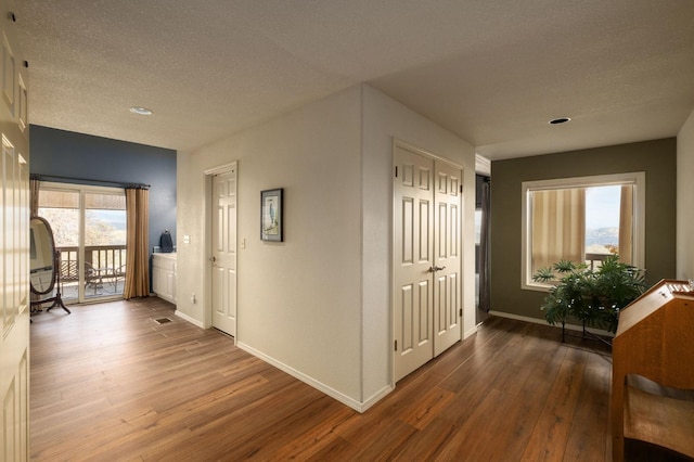 hallway featuring wood-type flooring and a textured ceiling