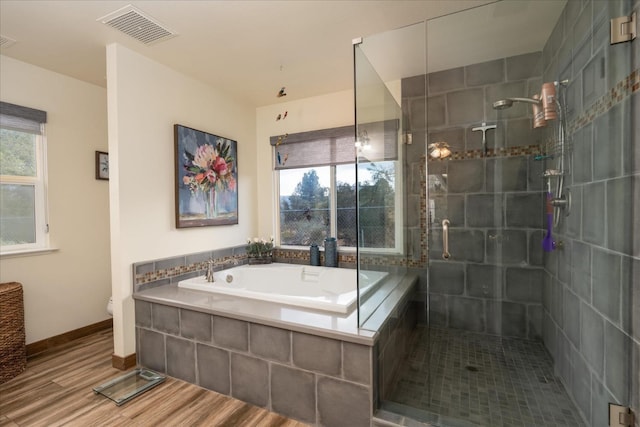 bathroom featuring hardwood / wood-style flooring, separate shower and tub, and toilet