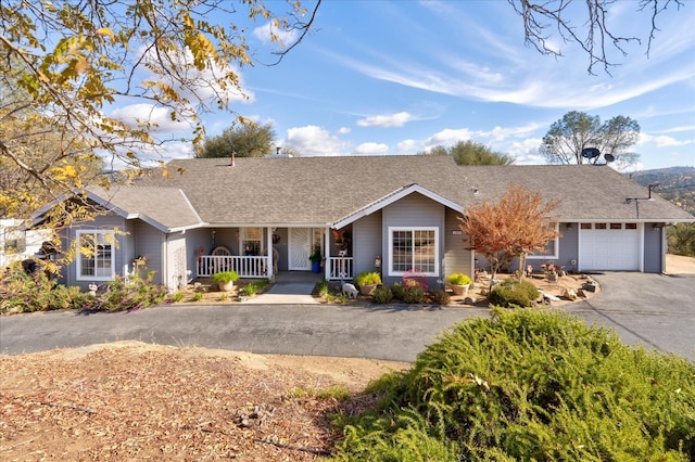 ranch-style home featuring covered porch and a garage