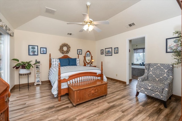 bedroom featuring wood-type flooring, ensuite bath, ceiling fan, and lofted ceiling