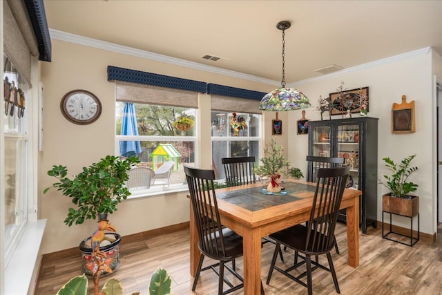 dining area with hardwood / wood-style floors and ornamental molding