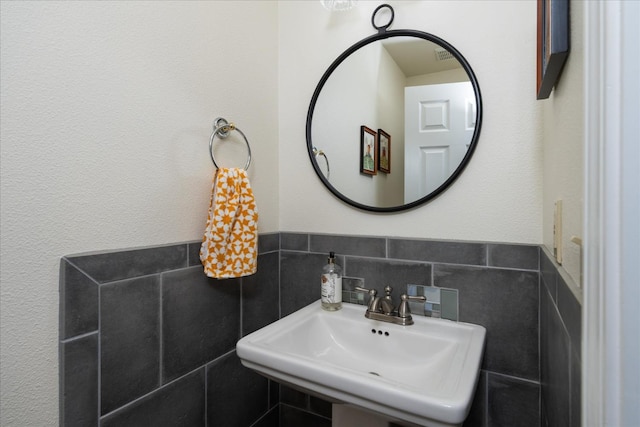 bathroom with sink and tile walls