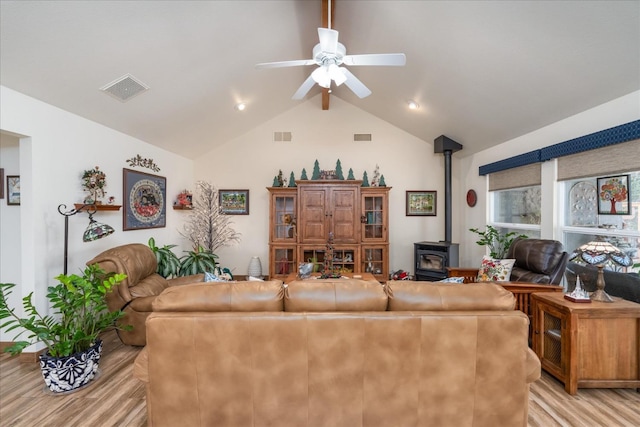 living room with a wood stove, ceiling fan, light hardwood / wood-style flooring, and lofted ceiling