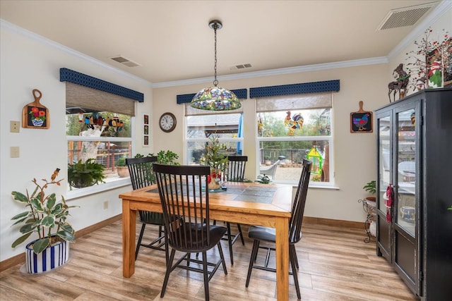 dining area with light hardwood / wood-style floors and ornamental molding