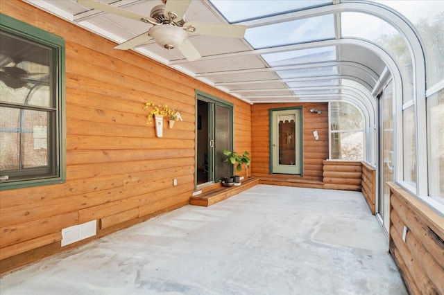 unfurnished sunroom with ceiling fan