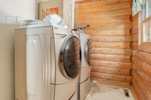 laundry area with separate washer and dryer and light tile patterned flooring