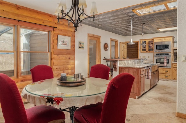 dining room with wooden walls and a notable chandelier