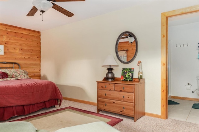 carpeted bedroom featuring ceiling fan and wood walls