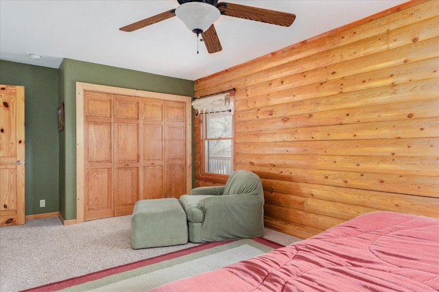 carpeted bedroom featuring ceiling fan, a closet, and log walls