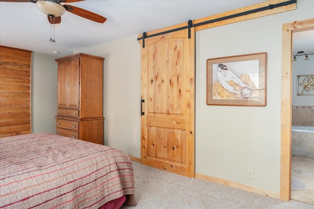 carpeted bedroom featuring ceiling fan and a barn door