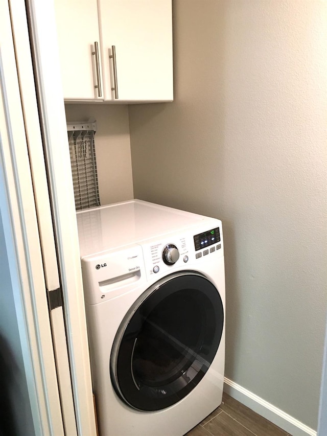 laundry room with washer / clothes dryer, dark wood-type flooring, and cabinets