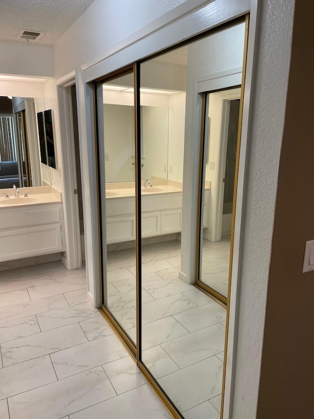 bathroom with vanity and a textured ceiling