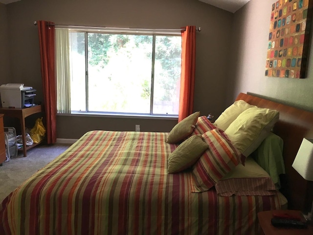 bedroom featuring multiple windows, carpet, and vaulted ceiling