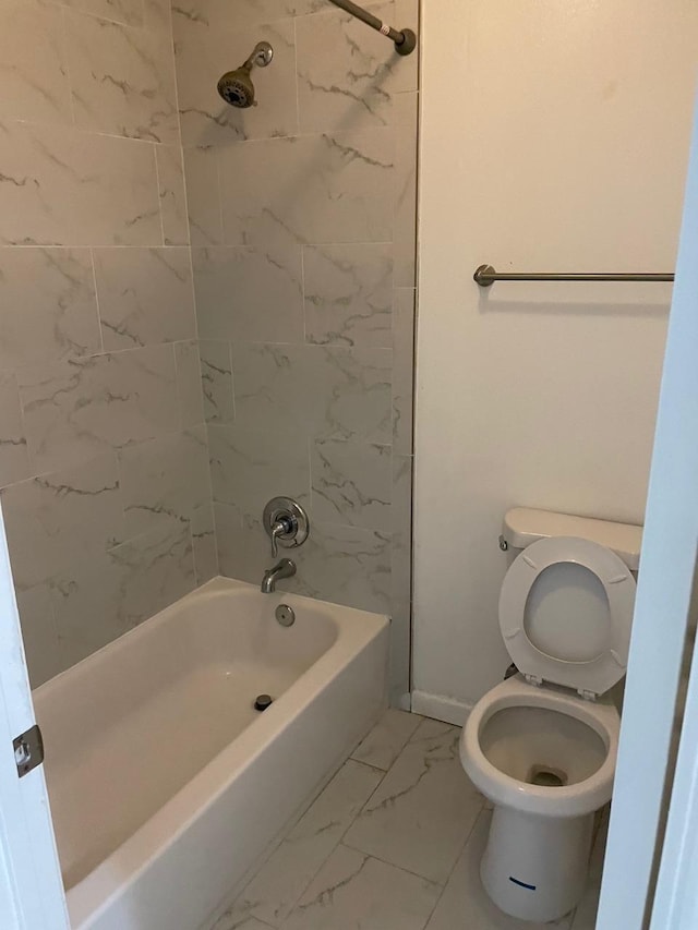 bathroom featuring toilet and tiled shower / bath