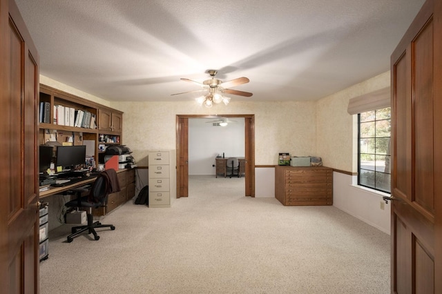 carpeted office featuring a textured ceiling and ceiling fan