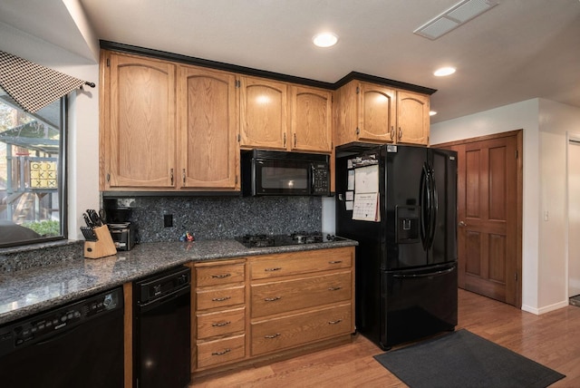 kitchen with decorative backsplash, plenty of natural light, black appliances, and light wood-type flooring