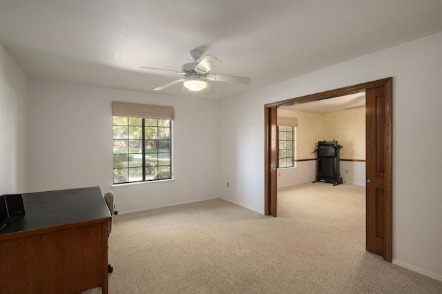 unfurnished office with ceiling fan and light colored carpet