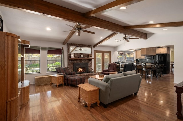 living room featuring vaulted ceiling with beams, a wealth of natural light, and hardwood / wood-style floors