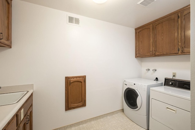 laundry room featuring light tile patterned flooring, cabinets, independent washer and dryer, and sink