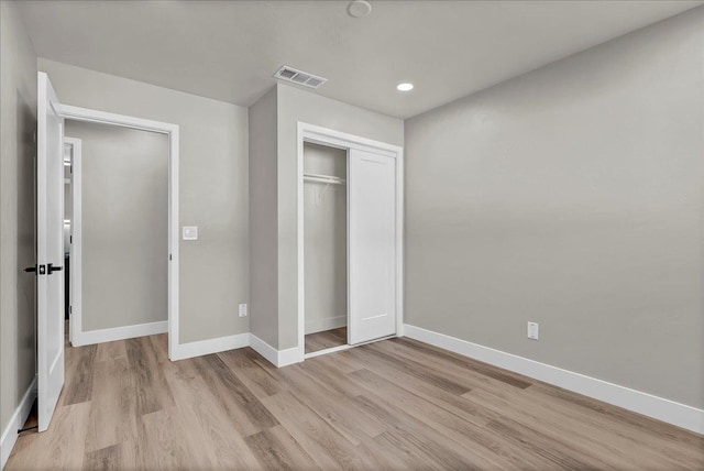 unfurnished bedroom featuring a closet and light wood-type flooring