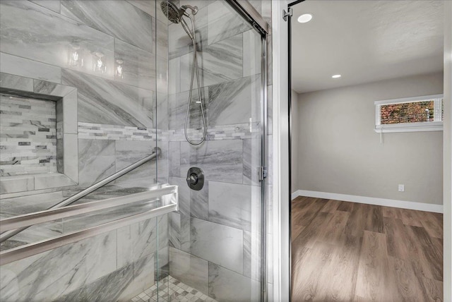 bathroom with hardwood / wood-style flooring and a shower with door