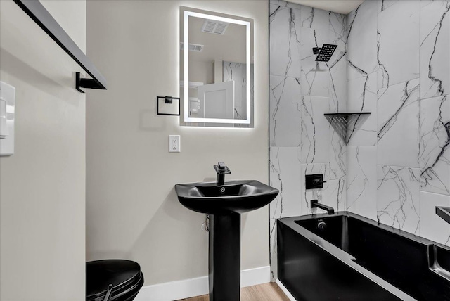 full bathroom featuring sink, shower / bathing tub combination, wood-type flooring, and toilet