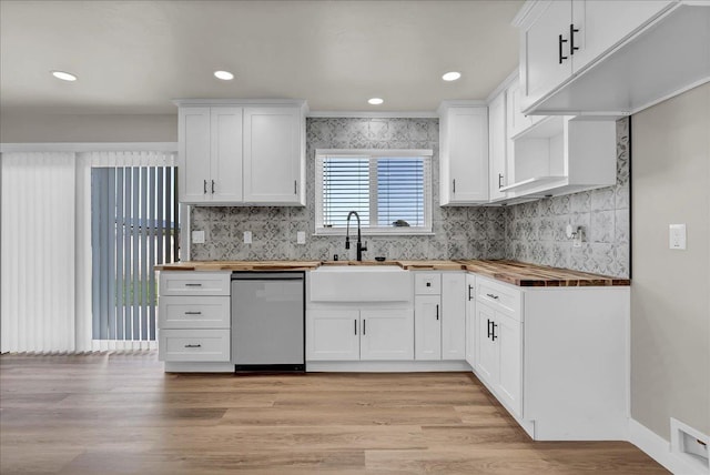 kitchen featuring dishwasher, white cabinetry, and butcher block counters