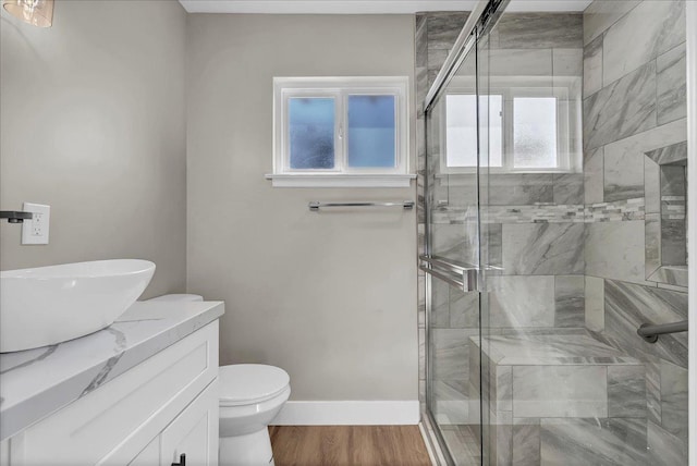 bathroom featuring walk in shower, hardwood / wood-style floors, vanity, and plenty of natural light