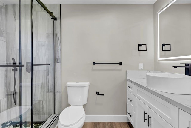 bathroom featuring hardwood / wood-style floors, vanity, toilet, and walk in shower