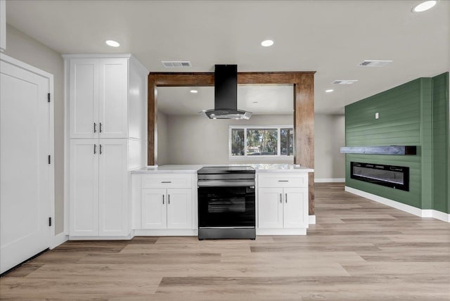 kitchen with white cabinetry, extractor fan, light wood-type flooring, and black range with electric cooktop