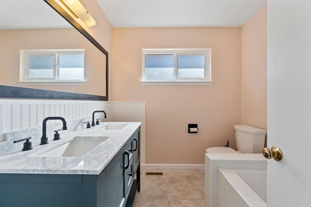 bathroom with plenty of natural light, vanity, and toilet