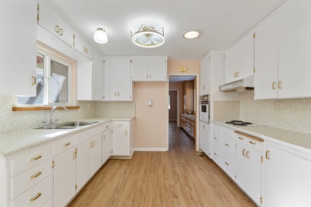 kitchen featuring light hardwood / wood-style floors, white cabinetry, sink, and tasteful backsplash