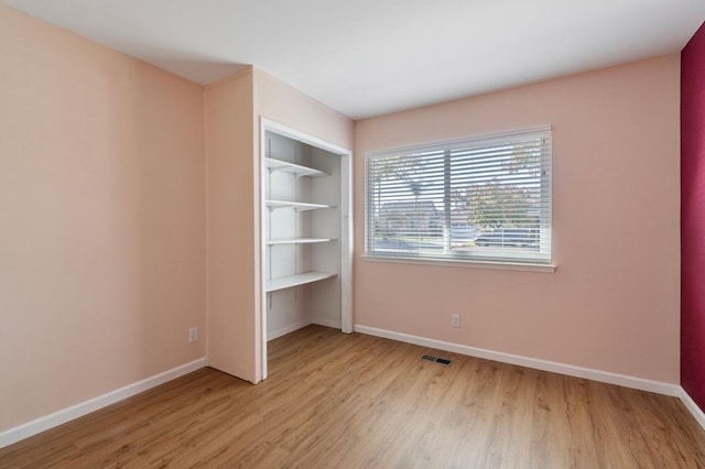 unfurnished bedroom with a closet and light hardwood / wood-style floors