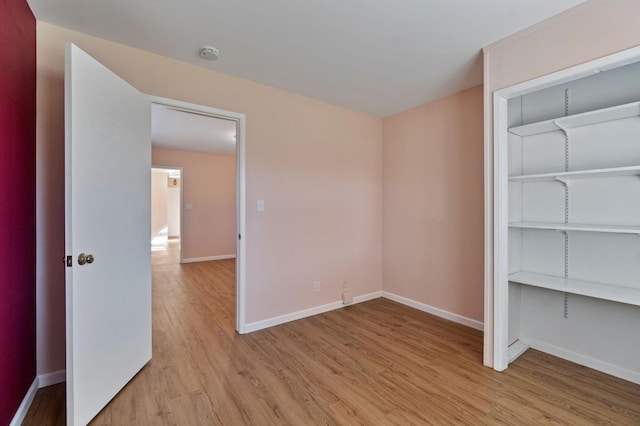 unfurnished bedroom with light hardwood / wood-style floors and a closet