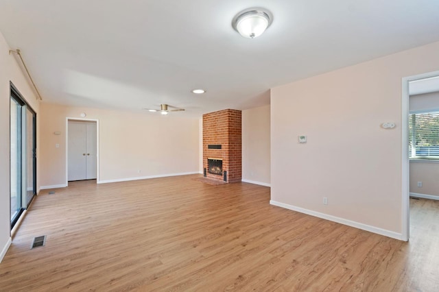 unfurnished living room with ceiling fan, light hardwood / wood-style floors, and a brick fireplace