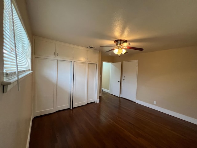 unfurnished bedroom featuring ceiling fan and dark hardwood / wood-style floors