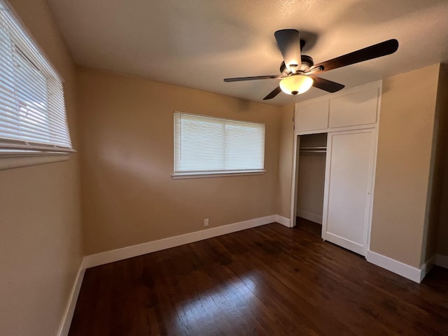 unfurnished bedroom featuring dark hardwood / wood-style floors, ceiling fan, and a closet