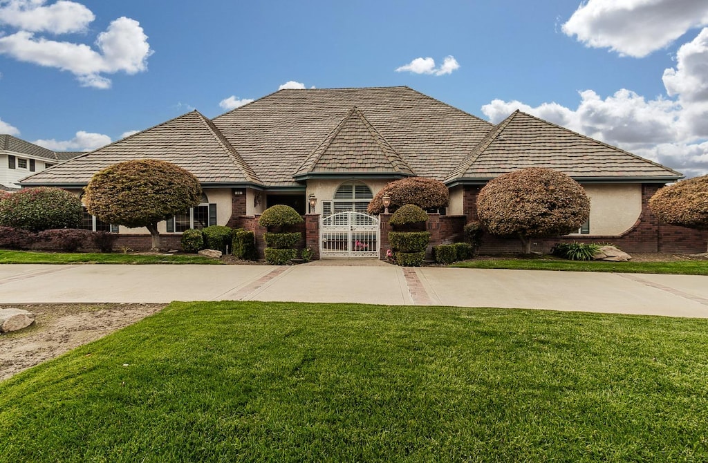 french country inspired facade featuring a front lawn