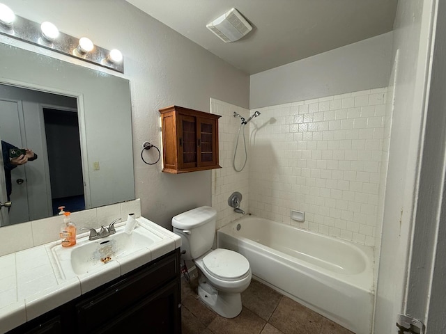 full bathroom with toilet, tile patterned flooring, tiled shower / bath, and vanity