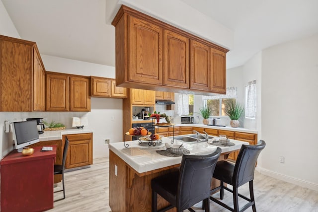 kitchen with a breakfast bar, a kitchen island, and light wood-type flooring