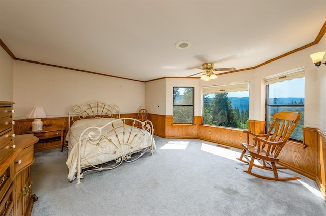 bedroom with ceiling fan, crown molding, and wood walls