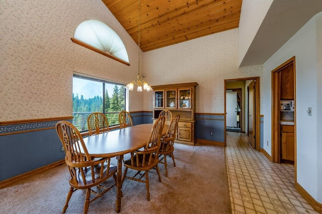 carpeted dining room featuring wood ceiling, high vaulted ceiling, and an inviting chandelier