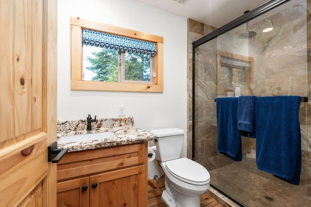 full bathroom with toilet, a shower stall, and vanity