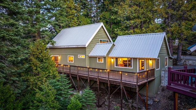 back of house featuring a deck and metal roof