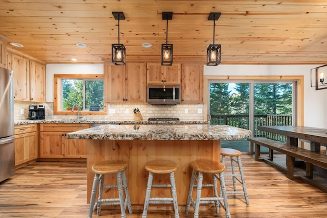 kitchen featuring light wood-style floors, wood ceiling, stainless steel appliances, and light brown cabinetry