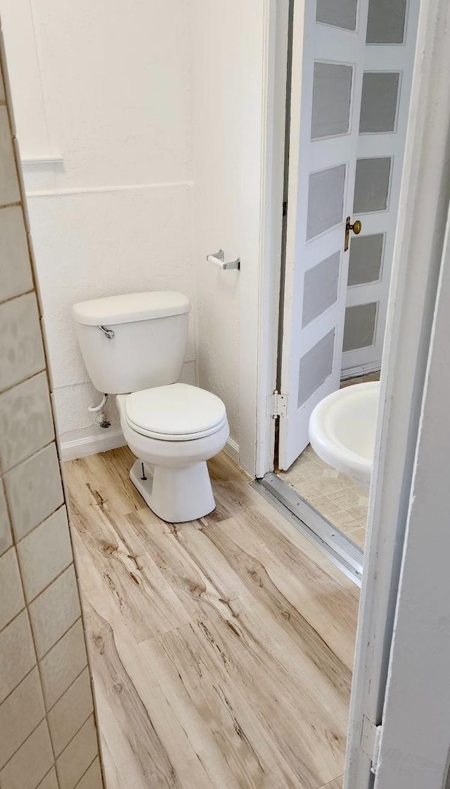 bathroom with hardwood / wood-style floors and toilet